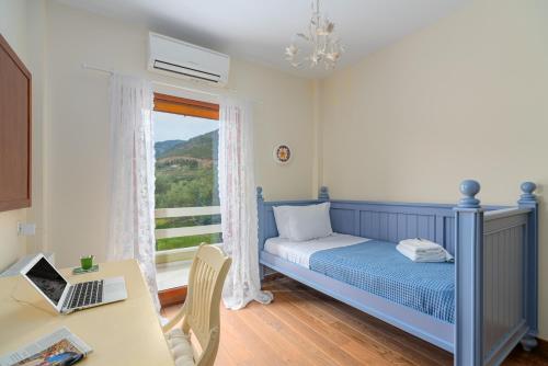 a bedroom with a bed and a desk with a laptop at SUN VILLA GLYFADA in Glyfada Fokidas