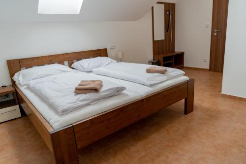 a large bed with white sheets and towels on it at Pension Florián in Pavlov