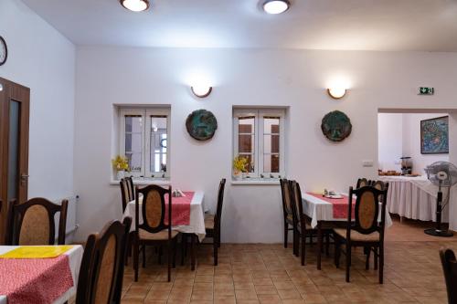 a restaurant with tables and chairs in a room at Pension Florián in Pavlov
