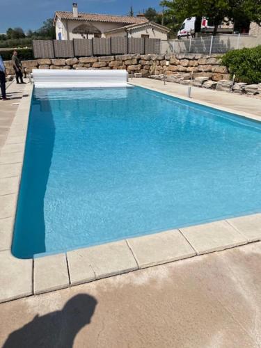 a shadow of a person standing next to a swimming pool at Maëliette in Montclus