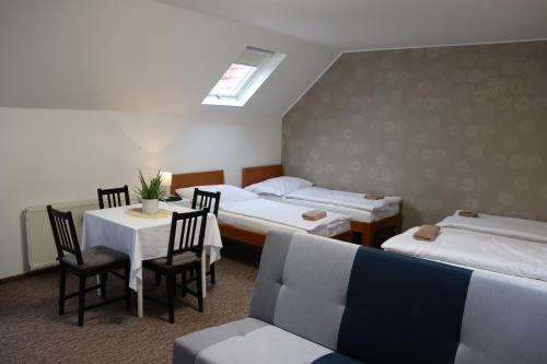 a hotel room with two beds and a table and chairs at Pension Florián in Pavlov