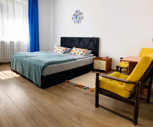 1 dormitorio con 1 cama y 1 silla amarilla en Krysia - tuż przy plaży, en Mielno