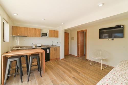 a kitchen and living room with a table and chairs at Mawün Hotel Pucón in Pucón