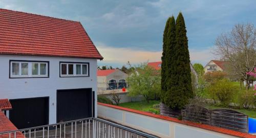 a white house with a red roof and two trees at Hotel Casa Andalucia in Hallbergmoos
