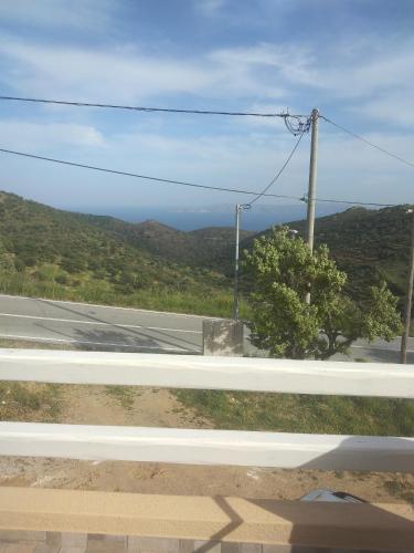 a view from a window of a road with a mountain at Αγ Νικόλαος Karthaia in Elliniká