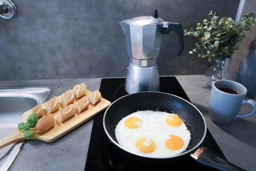 - une poêle à frire avec des œufs et du pain sur un comptoir de cuisine dans l'établissement Studio Le café gourmand - Proche Gare - Coin tranquille, à Mulhouse