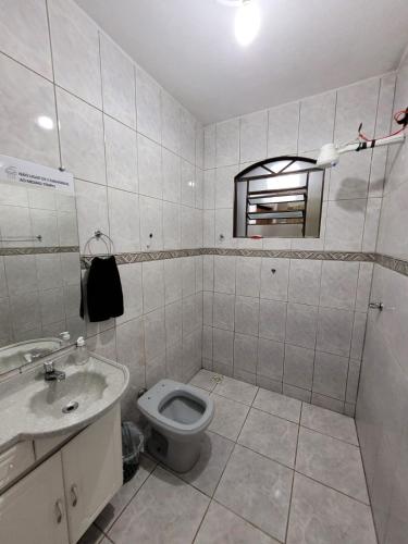 a bathroom with a toilet and a sink at Casa Grande para Família e Amigos in São Lourenço