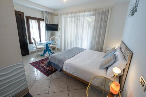 a bedroom with a bed and a television and a table at Casa di Carlo Goldoni - Dimora Storica in Chioggia