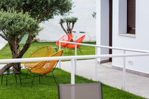 a group of chairs sitting on a porch at Apartamentos Rurales Cielo de Monfragüe in Malpartida de Plasencia