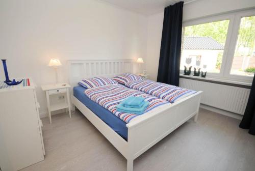 una camera da letto con un letto con cuscini a righe e una finestra di Haus Sonneneck a Haffkrug