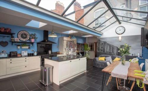 a kitchen and living room with a table and a couch at Beautiful 5 bedroom house in great location. in Spon End