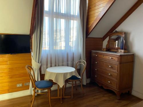 a room with a table and chairs and a window at Hotel Casa Somerscales in Valparaíso