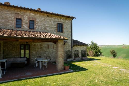 an external view of a stone house with a patio at Podere Sant'Antonio in Asciano