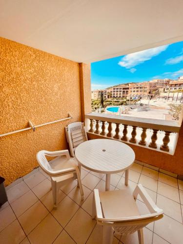 un balcon avec une table, des chaises et une fenêtre dans l'établissement Cap Esterel Studio Cabine  Vue Piscine Et Mer  Réf C2 308, à Saint-Raphaël