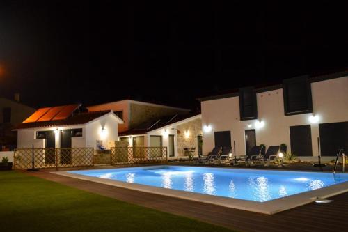 uma piscina em frente a uma casa à noite em Casa GANCHINHO em Santiago da Guarda