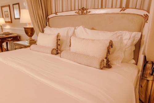 a white bed with white pillows and a white bedspread at Villa do Vale Boutique Hotel in Blumenau
