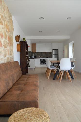 a living room with a couch and a table and chairs at Casa GANCHINHO in Santiago da Guarda