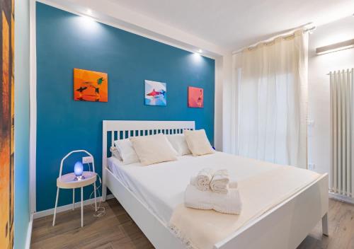 Dormitorio azul con cama blanca y pared azul en Penthouse Alps Apartment, en Turín