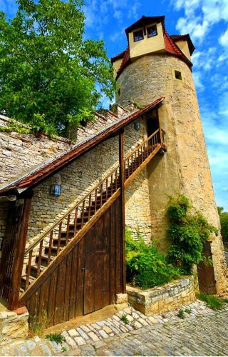 a building with a wooden gate and a tower at Ferienwohnung Hornig Zwei Terrassen, Parkplatz, separater Eingang in Sulzfeld am Main