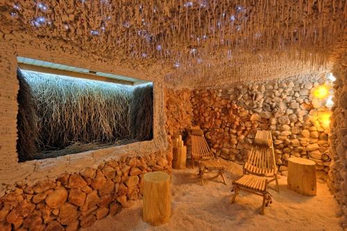 a room with a stone wall with chairs and a window at Harda House Friends & Spa in Zakopane