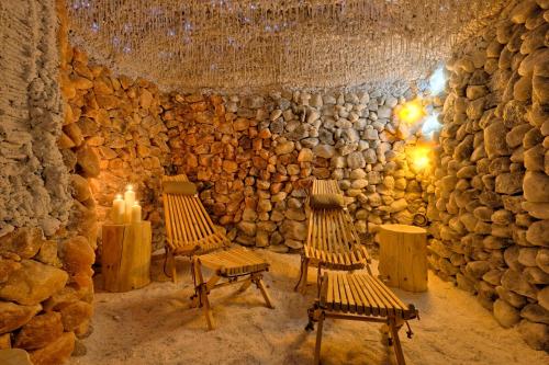 a room with two benches and a stone wall at Harda House Friends & Spa in Zakopane