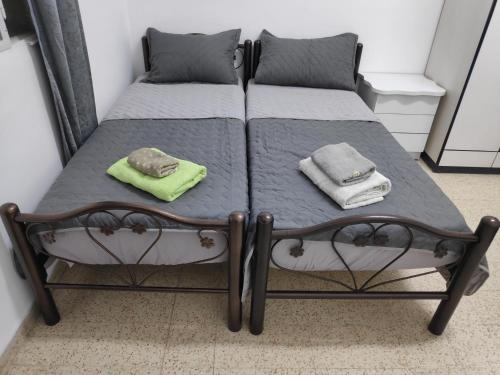 two beds in a small room with towels on them at Dar Jacaman - In the heart of Bethlehem old city in Bethlehem