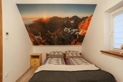 two beds in a room with a painting on the wall at Domek JuKa in Biały Dunajec