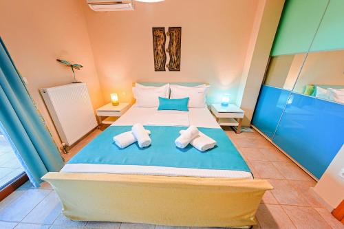 a bedroom with a large bed with towels on it at Villa Mariellie in Néa Péramos