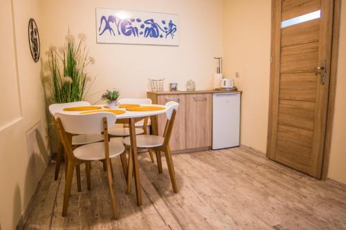 a kitchen with a table and chairs in a room at Noclegi Fregata - Pokoje Gościnne w Solinie 661-459-339 in Solina