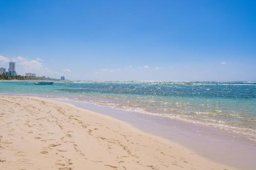 una playa con huellas en la arena y el océano en Coral Costa Caribe Beach Resort - All Inclusive en Juan Dolio