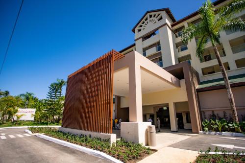 ein Gebäude mit einem Holzzaun neben einer Straße in der Unterkunft Coral Costa Caribe Beach Resort - All Inclusive in Juan Dolio