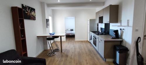 - une cuisine avec une table et un comptoir dans une pièce dans l'établissement charmant F2 entre Bastia et St Florent, à Biguglia