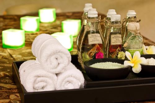 a tray with towels and soap and a bowl of cosmetics at Bali Rani Hotel in Kuta