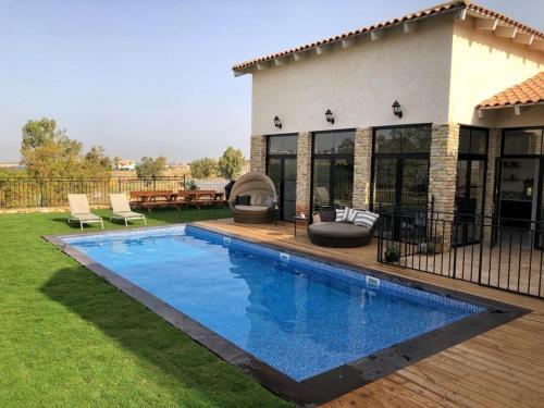 een zwembad in de tuin van een huis bij לבנדר בגלבוע בריכה מחוממת 4 חדרי שינה in Nurit