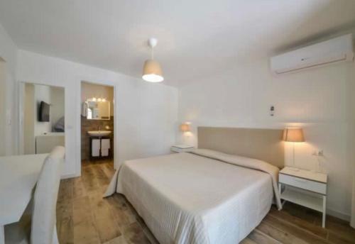 a bedroom with a large white bed and a bathroom at B&B Villa D'Amato in Peschici