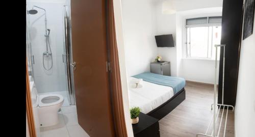 uma casa de banho com uma cama, um WC e um chuveiro em Apartamento pensamento IV em Lisboa