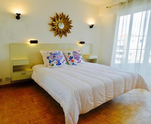 1 dormitorio con 1 cama blanca grande y espejo en la pared en Elegant & Luminous 2-BR - Antibes City Center, en Antibes