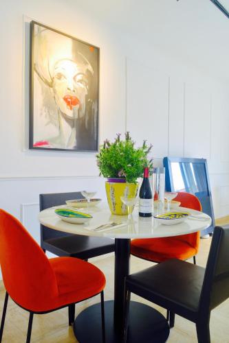 une table à manger avec des chaises rouges et un tableau dans l'établissement Elegant & Luminous 2-BR - Antibes City Center, à Antibes