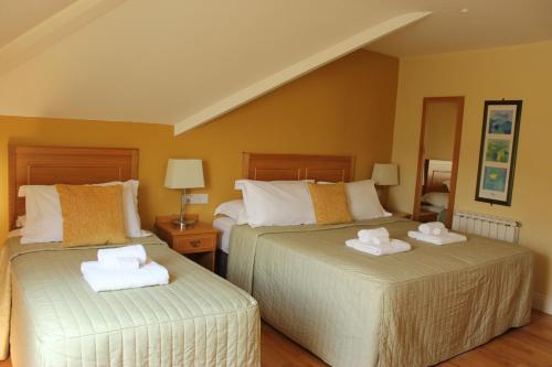 two beds in a room with towels on them at Inch Beach House B&B in Inch