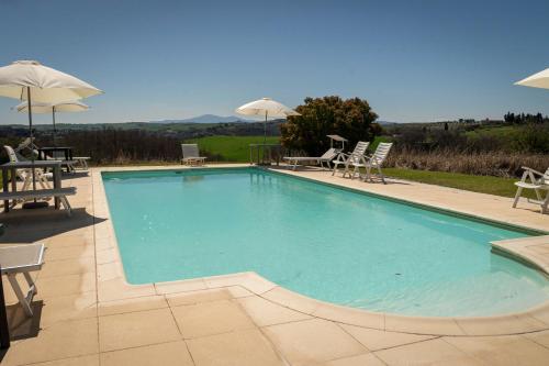 a large swimming pool with chairs and umbrellas at Podere Sant'Antonio in Asciano