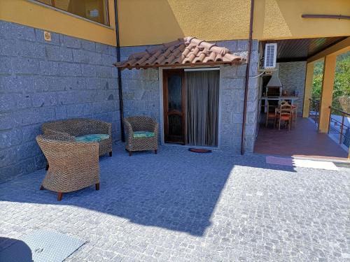 a patio with a table and chairs and a building at Casa Amarela da Caniçada in Vieira do Minho