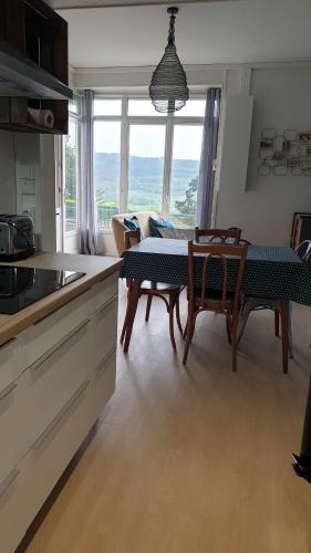 une cuisine et une salle à manger avec une table et des chaises dans l'établissement Rez de jardin vue mer Costa Bella, à Criel-sur-Mer