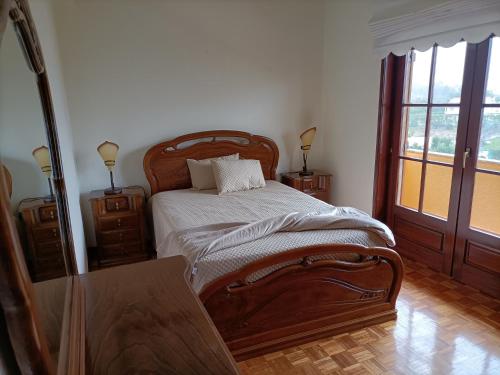 a bedroom with a wooden bed and two night stands at Casa Amarela da Caniçada in Vieira do Minho