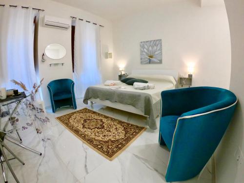 una camera con un letto e due sedie blu di Guest Room historic centre a Iglesias