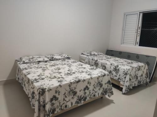 a bedroom with two beds and a window at Casa com vista incrível para o Lago de Furnas in Capitólio