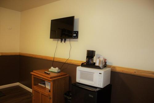a room with a microwave and a tv on a wall at Fireside Lodge in Big Bear Lake