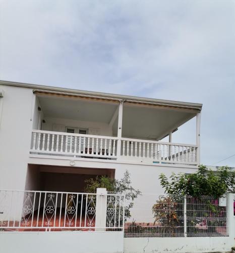 a white building with a balcony and a fence at Villaventure in Le Vauclin