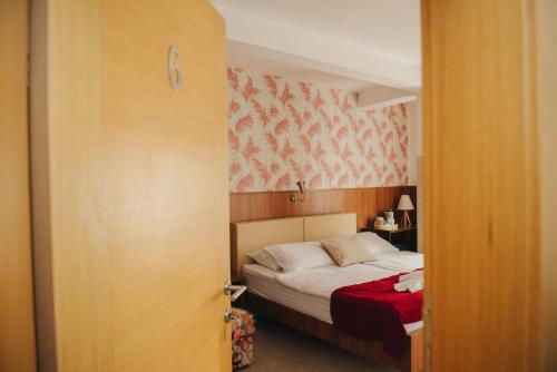 a bedroom with a bed with a red blanket at Hotel - Villa Lejla in Mostar