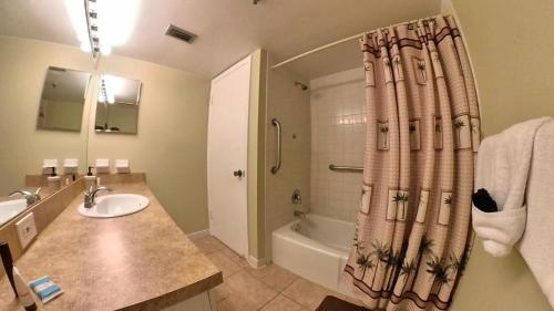 ein Bad mit einem Waschbecken und einem Duschvorhang in der Unterkunft Sea Club Condo #103 in Clearwater Beach