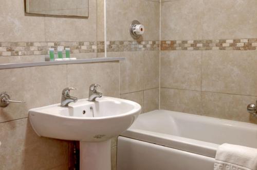 a bathroom with a sink and a bath tub at Sure Hotel by Best Western Reading in Reading